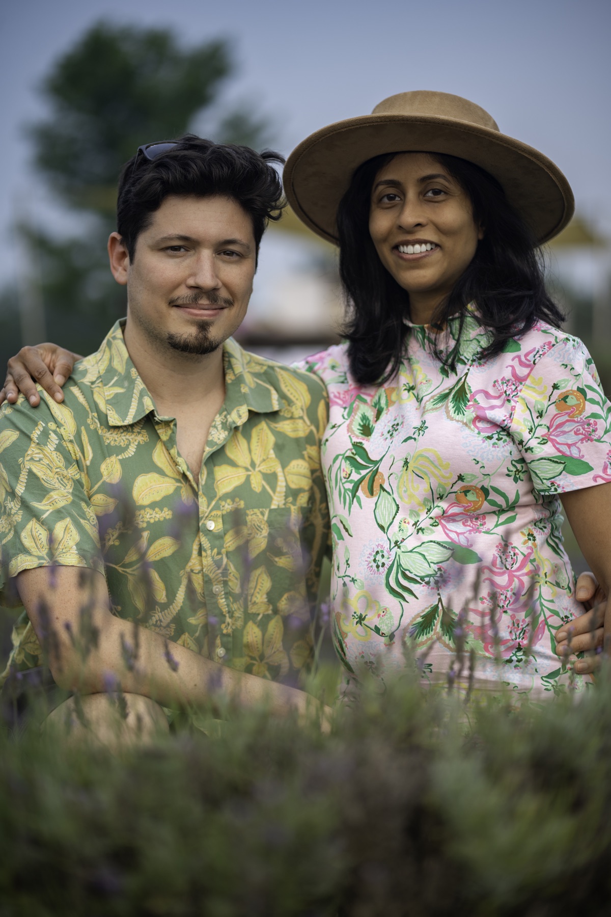 Expecting couple seated together in a field