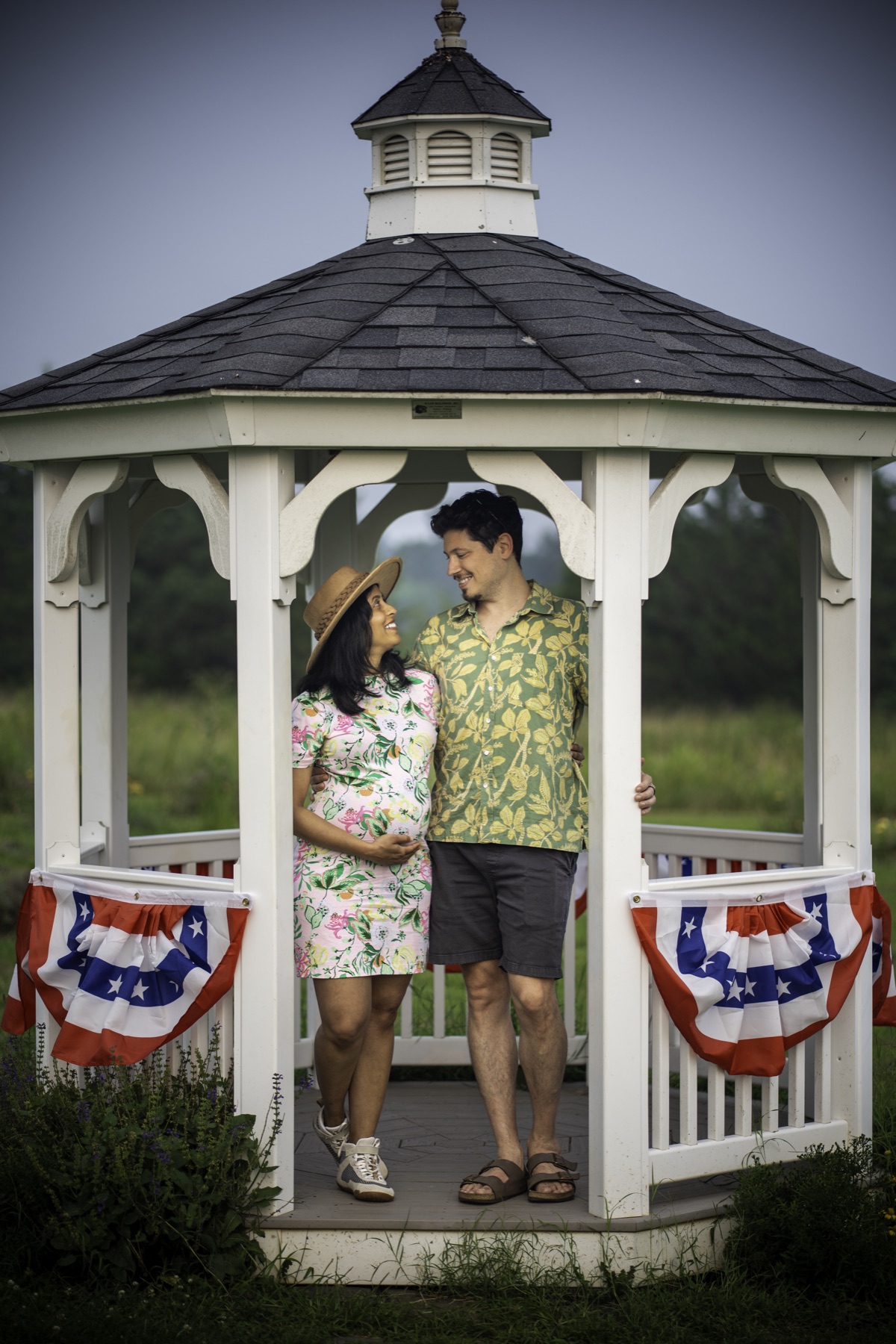 Expecting couple standing together in a gazebo